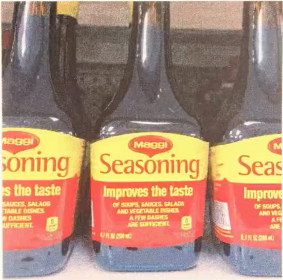 Photograph of Maggi Seasoning bottles lined up, from an ongoing series on Vietnamese American pantry staples.