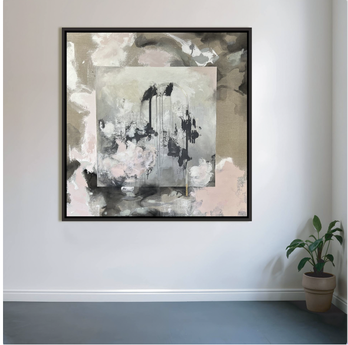 Framed square painting installed on a white gallery wall — soft washes of blush, taupe, and grey with black ink drips forming a ghostly arched form at center.