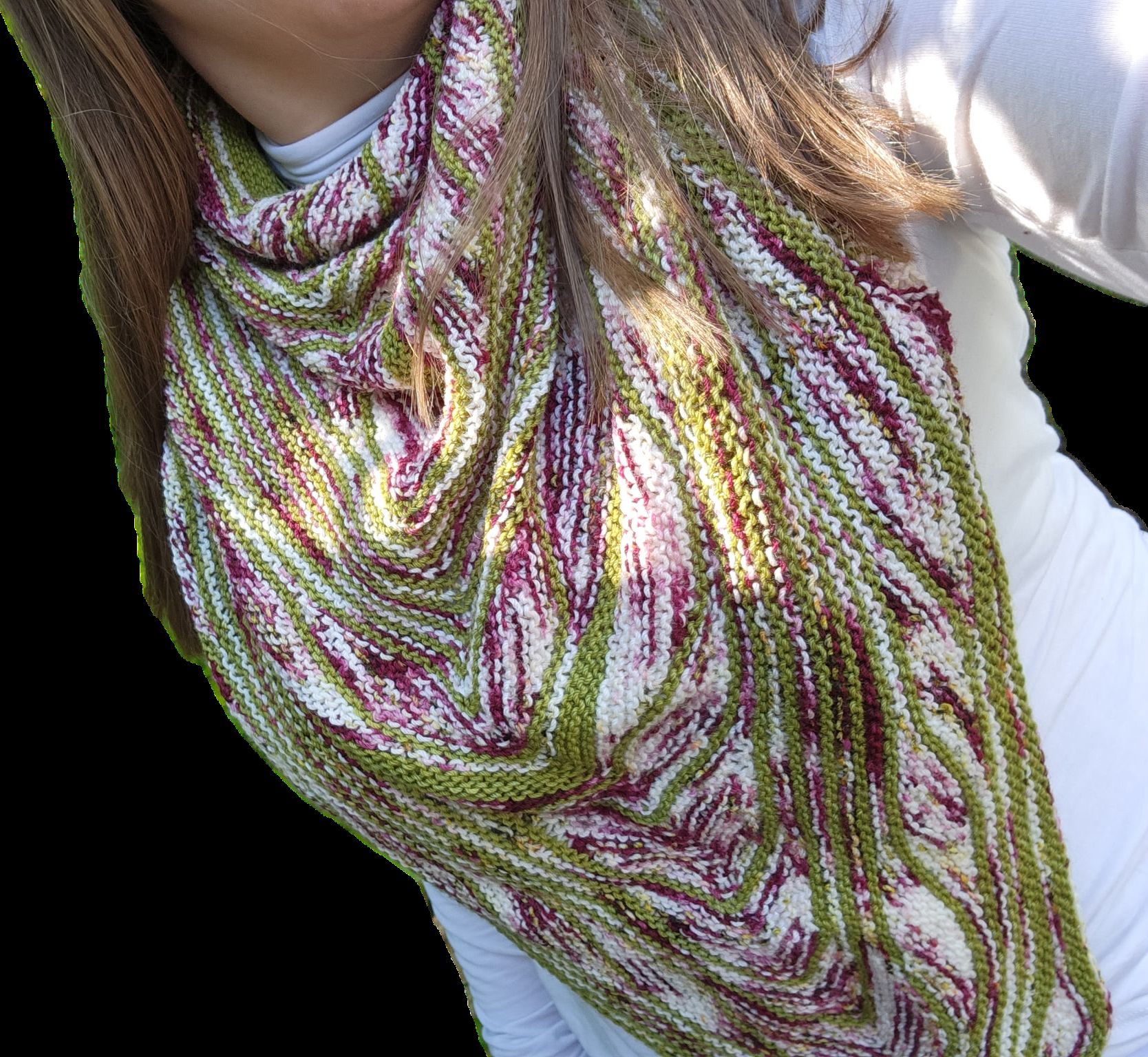 A hand-knit shawl in green, magenta, and cream stripes wrapped around the shoulders.